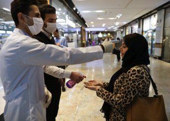 Una mujer se somete a un control de temperatura mientras se desinfecta las manos al entrar al centro comercial Palladium, en Teherán, Irán, el 3 de marzo de 2020. Foto: Vahid Salemi / AP.