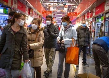 Varias personas con mascarillas compran en un mercado en Beijing, el 14 de marzo de 2020. Foto: AP/Mark Schiefelbein.