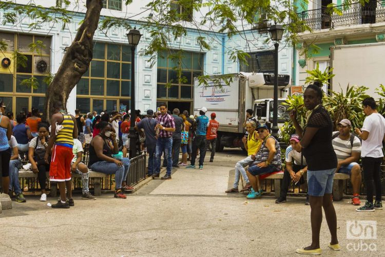 Cubanos hacen una cola en las afueras de un centro comercial en La Habana, en momentos en que el gobierno de la la Isla ha llamado a practicar el aislamiento social como medida para evitar el contagio de la COVID-19. Foto: Otmaro Rodríguez.
