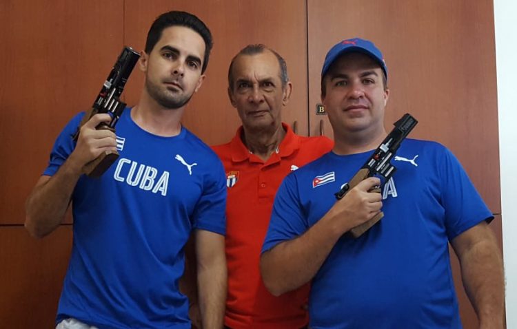 Los tiradores cubanos Jorge Félix Álvarez (izquierda) y Leuris Pupo (derecha), junto a su entrenador Meinardo Torres (centro). Foto: Revista Alma Máter / Archivo.