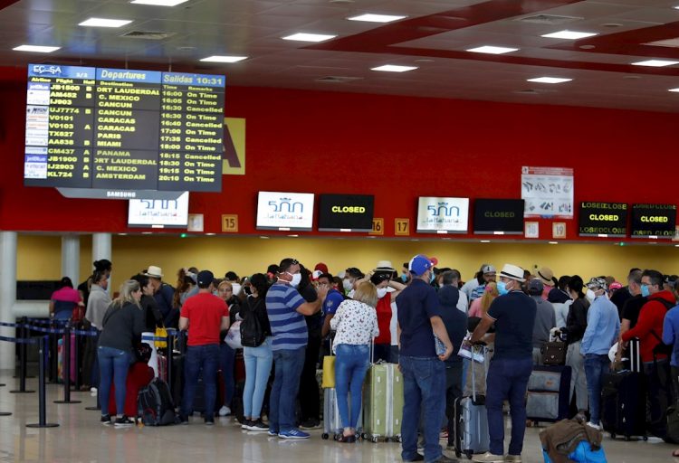 Un grupo de personas esperan la salida de sus vuelos antes del cierre parcial de las fronteras cubanas para evitar la propagación de la COVID-19, en el Aeropuerto Internacional "José Martí" de La Habana, el 23 de marzo de 2020. Foto: Yander Zamora / EFE.