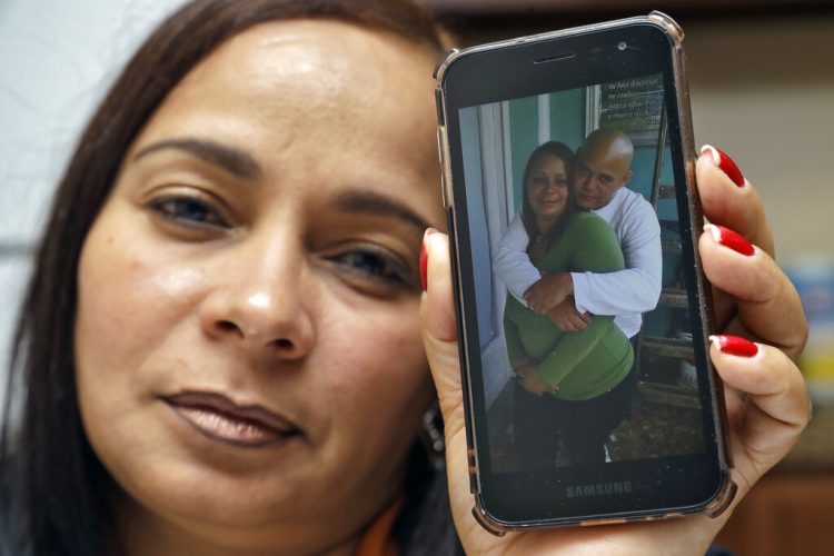 Yarelis Gutiérrez Barrios sostiene un celular con la fotografía de ella y su pareja Roylan Hernández Diaz, un solicitante de asilo en Estados Unidos que se suicidó en una celda de Luisiana. Foto: Chris O'Meara/AP.