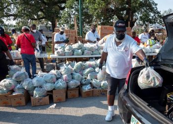 Decenas de voluntarios distribuyen comida gratis a los residente de la ciudad de Opa Lock, una de las urbes más pobres de la zona metropolitana de Miami. | Cristóbal HerreraEFE