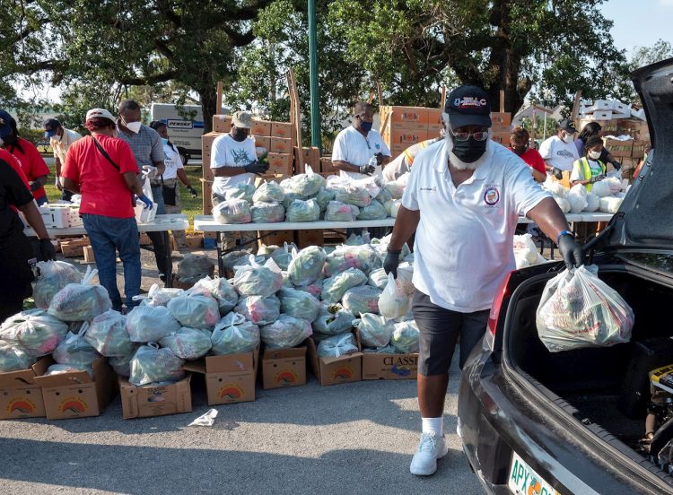 Decenas de voluntarios distribuyen comida gratis a los residente de la ciudad de Opa Lock, una de las urbes más pobres de la zona metropolitana de Miami. | Cristóbal HerreraEFE