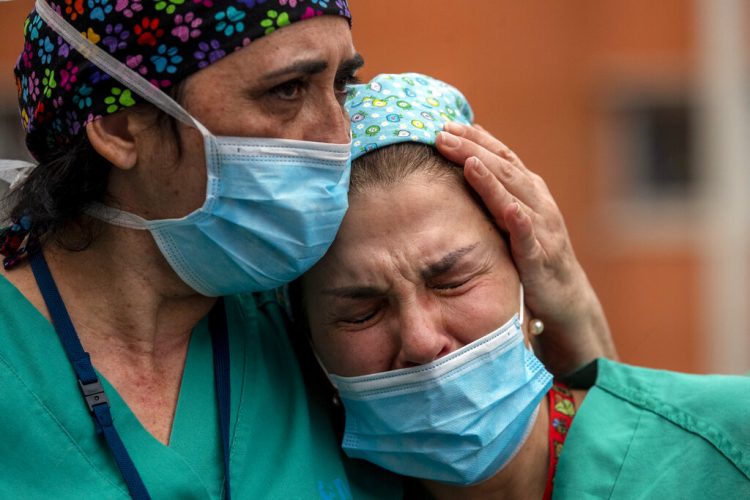 Empleadas médicas lloran durante un memorial para su colega Estaban, un enfermero que murió de coronavirus, en el hospital Severo Ochoa en Leganes, España, el viernes 10 de abril de 2020. Foto: Manu Fernández/AP.