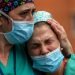 Empleadas médicas lloran durante un memorial para su colega Estaban, un enfermero que murió de coronavirus, en el hospital Severo Ochoa en Leganes, España, el viernes 10 de abril de 2020. Foto: Manu Fernández/AP.