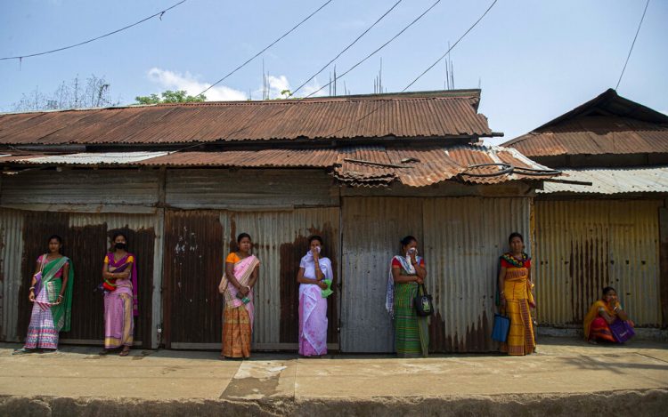 Varias mujeres hacen una cola manteniendo la distancia social en Daranggiri,  India, el lunes 20 de abril de 2020. Foto: Anupam Nath/AP.