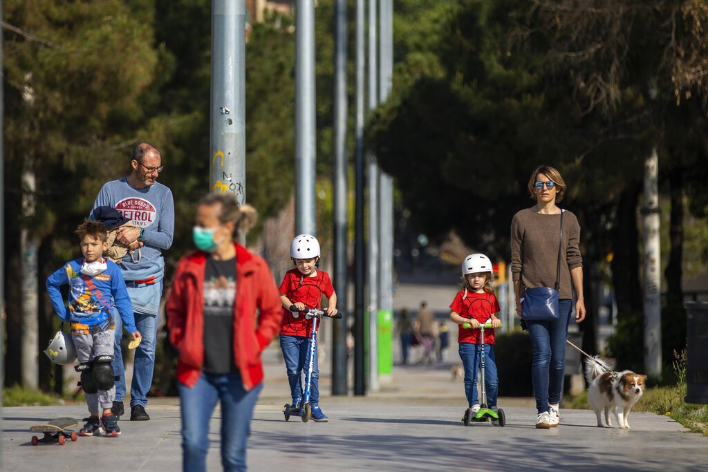 Padres e hijos caminan por un bulevar en Barcelona, España, durante la pandemia de coronavirus en el año 2020. Foto: Emilio Morenatti / AP / Archivo.