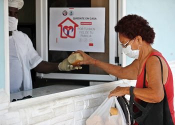 Una mujer con tapabocas compra pan en La Habana. Foto: EFE/Yander Zamora.