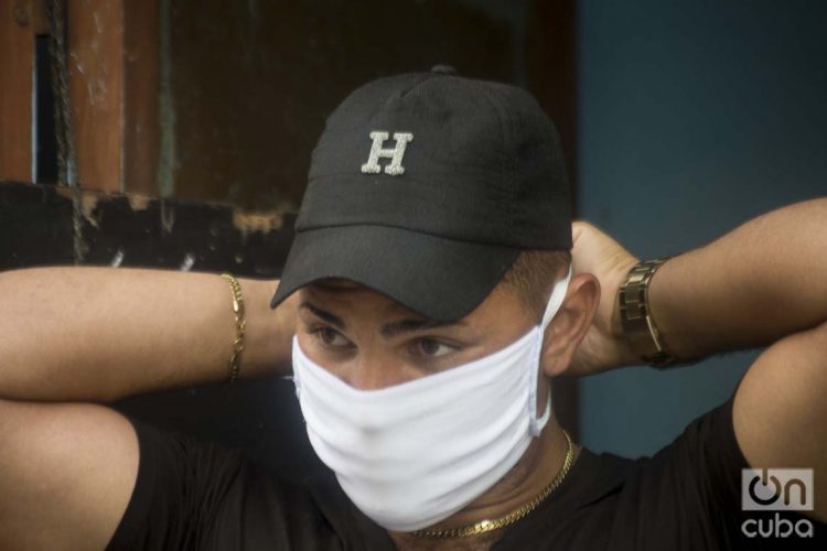 Un habanero se pone un nasobuco como medida de protección ante la pandemia de coronavirus. Foto: Otmaro Rodríguez.