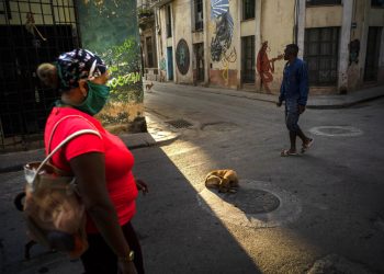 Una mujer camina con una mascarilla como precaución contra el nuevo coronavirus en La Habana. Foto: AP/Ramon Espinosa.