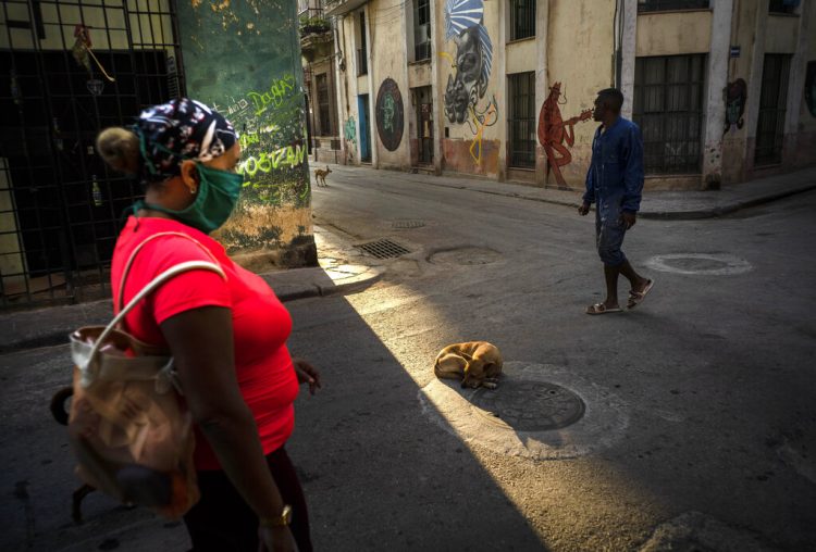 Una mujer camina con una mascarilla como precaución contra el nuevo coronavirus en La Habana. Foto: AP/Ramon Espinosa.