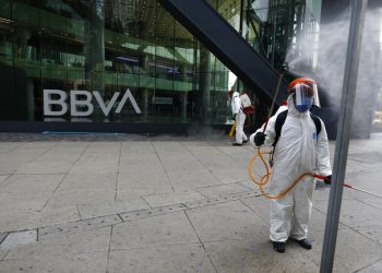 Trabajadores municipales rocían desinfectante frente al edificio del banco BBVA sobre la avenida Paseo de la Reforma en la Ciudad de México. Foto: Rebecca Blackwell/AP.