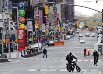 Peatones y ciclistas recorren la zona de Times Square en la ciudad de Nueva York, el viernes 17 de abril de 2020. Las calles de la ciudad están casi vacías mientras las personas prefieren mantenerse en casa para frenar los contagios de Covid-19. Las restrictiones, en vigencia desde el 22 de marzo, seguirán por lo menos hasta el 15 de mayo. Foto: AP /Frank Franklin II)