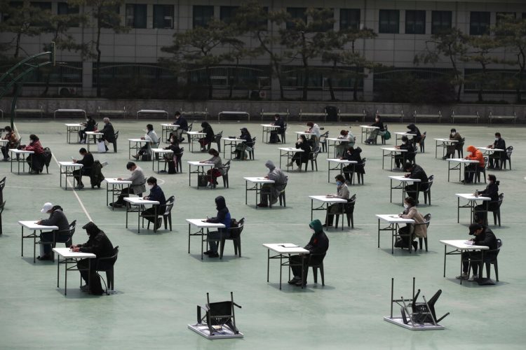 Solicitantes se preparan para tomar un examen oficial en Seúl, Corea del Sur, el 25 de abril de 2020. (AP Foto/Lee Jin-man)