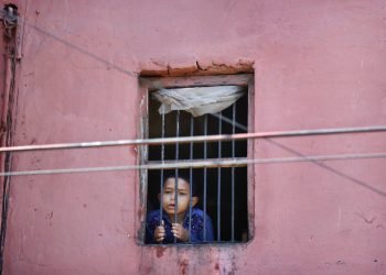 Un niño mira por la ventana de su casa en el barrio viejo de Nueva Delhi, India. Foto: Manish Swarup/Ap.
