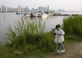 Una niña juega con su patineta en la ribera del río Yangtsé, en Wuhan, China, epicentro del brote mundial de coronavirus. Foto del 16 de abril de 2020, AP/Ng Han Guan.