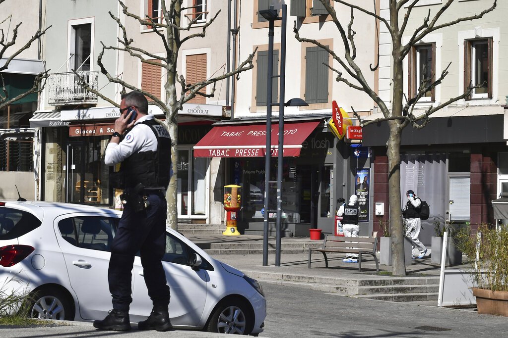 Un policía llama por celular después de que un hombre con un cuchillo atacara a residentes que salieron de compras en una población sometida a cuarentena el sábado 4 de abril de 2020 en Romans-sur-Isere, en el sur de Francia. Foto: AP.