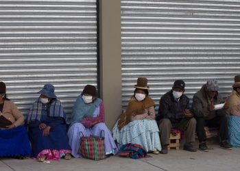 Ancianos, en su mayoria con mascarillas, esperan en fila a recibir su pensión mensual en La Paz, Bolivia, el jueves 9 de abril de 2020. Foto: Juan Karita/AP.