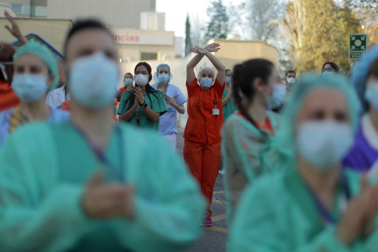 Trabajadores sanitarios aplauden a la gente que, desde sus casas, muestra su apoyo al personal que trabajaba para contener el brote de coronavirus, en el hospital Gregorio Marañón, en Madrid. Foto: AP Foto/Manu Fernández