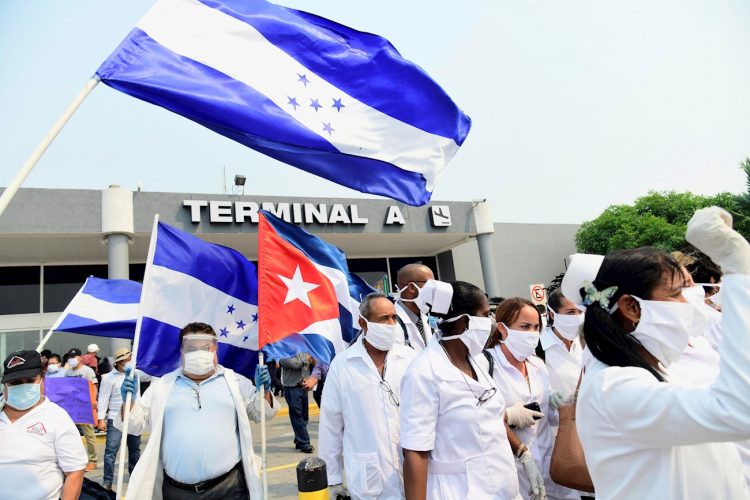 Integrantes de una brigada médica de Cuba saludan tras aterrizar en el Aeropuerto Internacional Ramón Villeda Morales de San Pedro Sula, Honduras. Foto: EFE/ José Valle/Archivo.