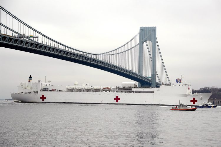 El buque hospital de la Marina "USNS Comfort" bajo el puente Verrazzano-Narrows mientras se dirigía a un muelle frente a las costas de Manhattan para ayudar con la pandemia de coronavirus en Nueva York. Foto: John Steward/AP.