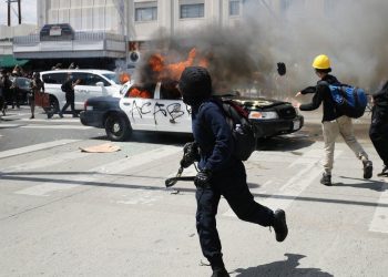Agentes antidisturbios en Los Ángeles, California, se enfrentaron con manifestantes que incendiaron al menos dos patrullas y dañaron a otros. Foto: AP.