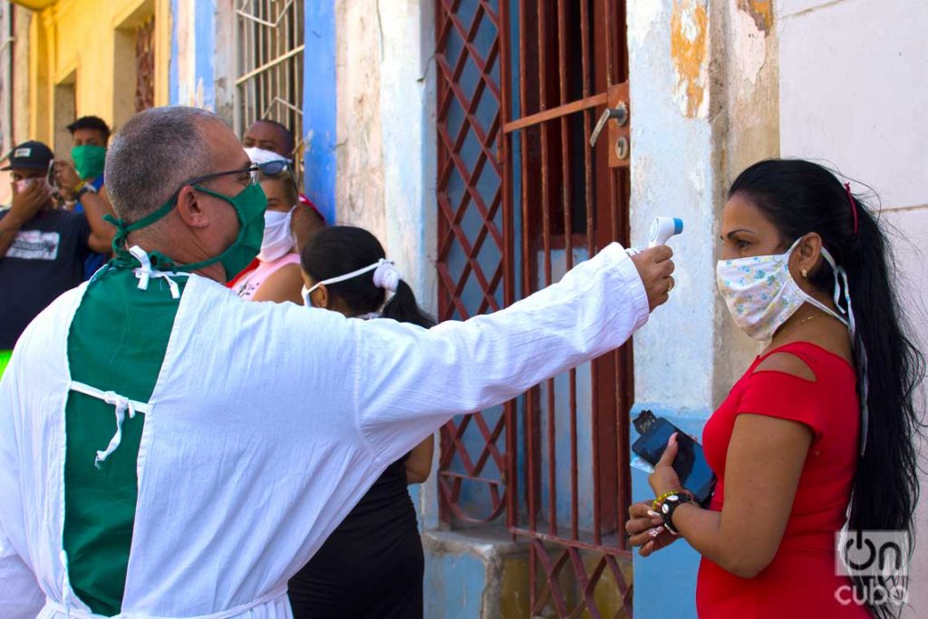 Un médico toma la temperatura antes de hacer prueba de la COVID-19, en Los Sitios, en La Habana. Foto: Otmaro Rodríguez / Archivo.