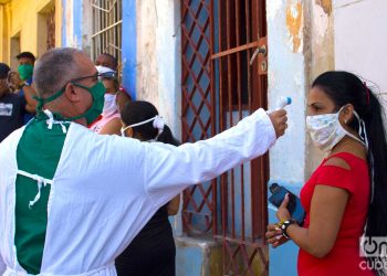 Un médico toma la temperatura antes de hacer prueba de la COVID-19, en Los Sitios, en La Habana. Foto: Otmaro Rodríguez / Archivo.