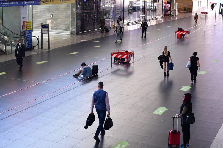 Las personas siguen las direcciones indicadas con flechas en el piso al interior de la estación de tren Termini en Roma, el lunes 4 de mayo de 2020. (Alfredo Falcone/LaPresse vía AP)
