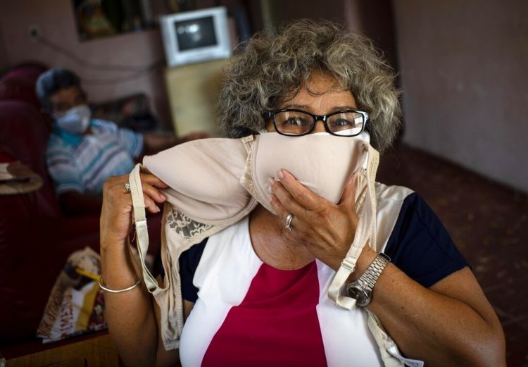 Idania Española, de 63 años, posa con un sostén que transformará en dos máscaras faciales, en medio de la propagación del nuevo coronavirus, en Cojimar, Cuba. (Foto: AP/Ramon Espinosa )