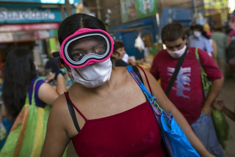 Una mujer usa una máscara quirúrgica y antiparras de buceo ante propagación del nuevo coronavirus. En Lima, Perú, el lunes 23 de marzo de 2020.  Foto: Rodrigo Abd/Ap.