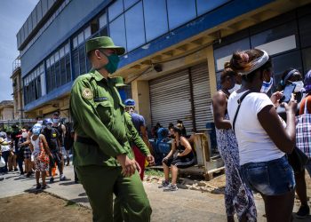Un soldado vigila afuera de una tienda estatal de comida donde las personas esperan en línea para entrar en La Habana, Cuba, el martes 19 de mayo de 2020. Foto: AP/Ramon Espinosa.