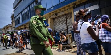 Un soldado vigila afuera de una tienda estatal de comida donde las personas esperan en línea para entrar en La Habana, Cuba, el martes 19 de mayo de 2020. Foto: AP/Ramon Espinosa.