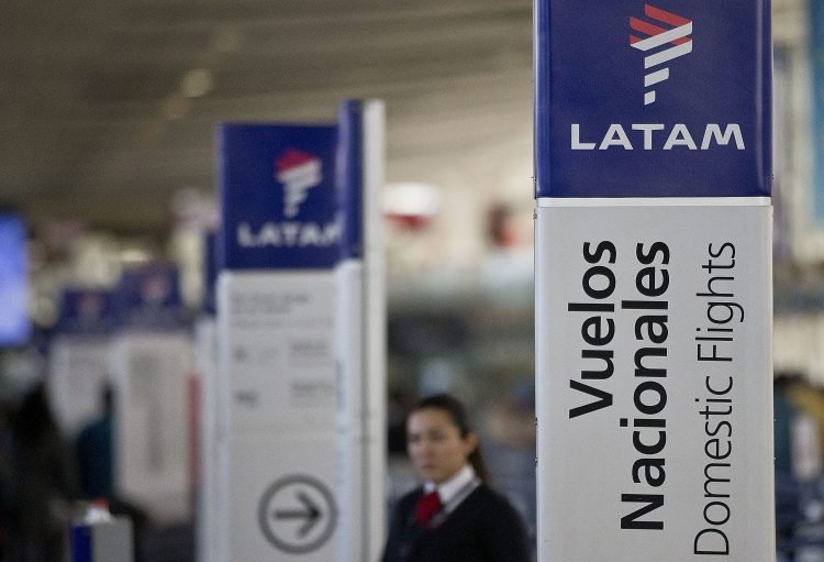 Una empleada de LATAM Airlines junto a los mostradores de facturación en el aeropuerto de Santiago de Chile. Foto: Esteban Félix/AP