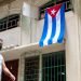 Un hombre pasa cerca de una bandera cubana colgada en una calle de La Habana, el 1 de mayo de 2020. Foto: Otmaro Rodríguez / Archivo.