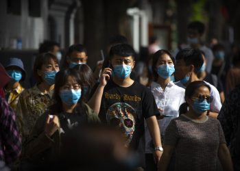 Personas con mascarillas para reducir los contagios de coronavirus caminan en una calle comercial en Beijing, el sábado 16 de mayo de 2020. Foto: Mark Sjefeelbein/ AP
