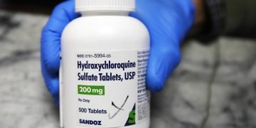 Fotografía de un frasco con tabletas de hicroxicloroquina en Oakland, California, mientras lo muestra un empleado farmacéutico. Foto: AP/Ben Margot.