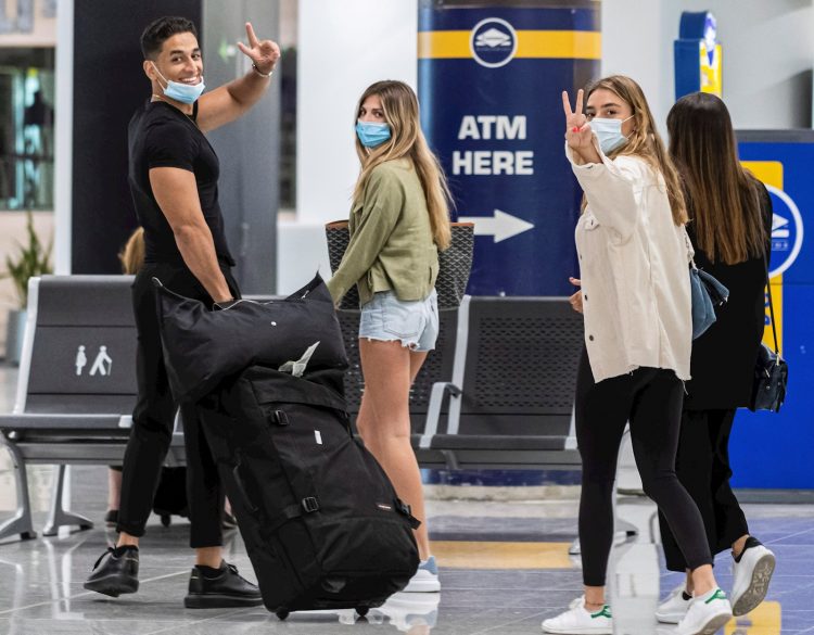 Viajeros ataviados con mascarillas a su llegada al Aeropuerto de Palma de Mallorca, este domingo, durante el primer día del fin del estado de alarma, en el que se espera la llegada de 25 vuelos internacionales. Foto: Cati Cladera / EFE.
