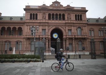 Un ciclista pasa por la Casa Rosada de Buenos Aires. Foto: Natacha Pisarenko/AP.