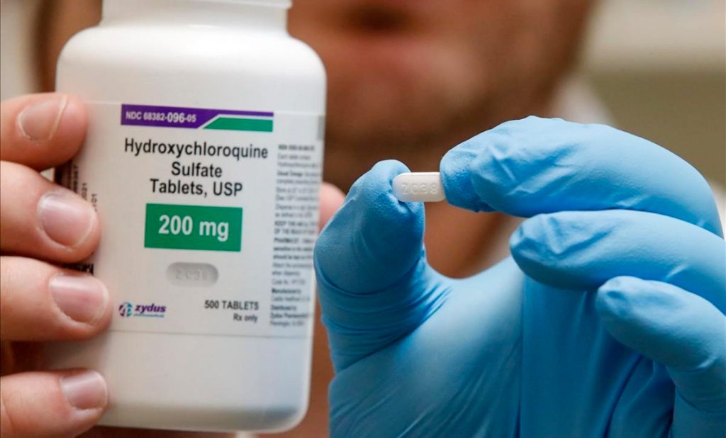 Un farmacéutico sostiene una píldora de hidroxicloroquina. Foto: AFP/George Frey.