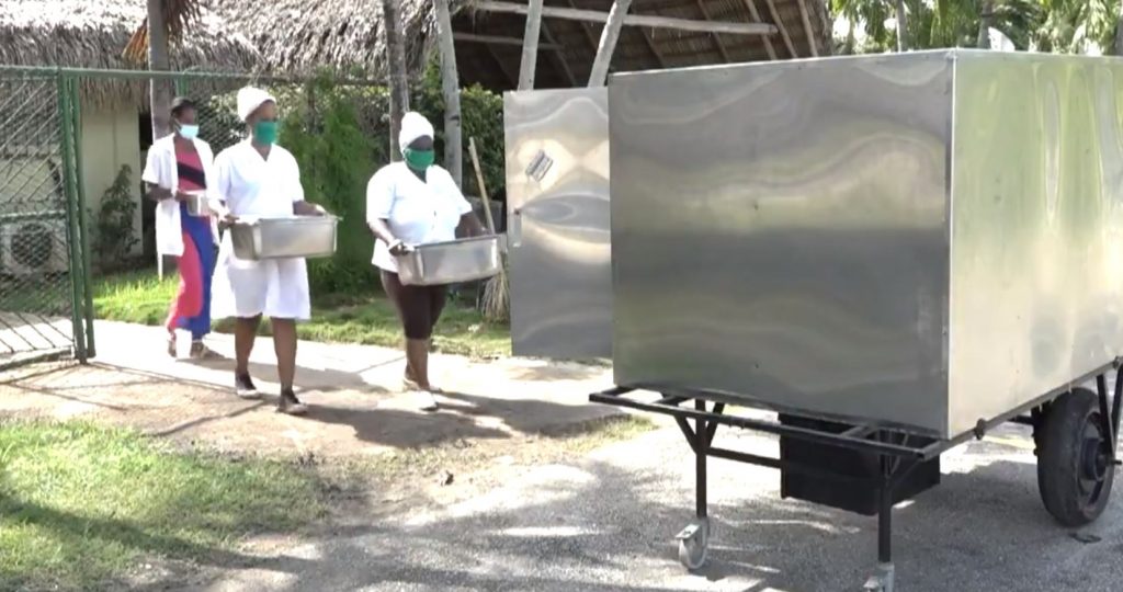 El robot cubano Palmiche (derecha) es utilizado para repartir alimentos en el centro de aislamiento de la CUJAE, en La Habana, durante la pandemia de coronavirus. Foto: Captura de pantalla.