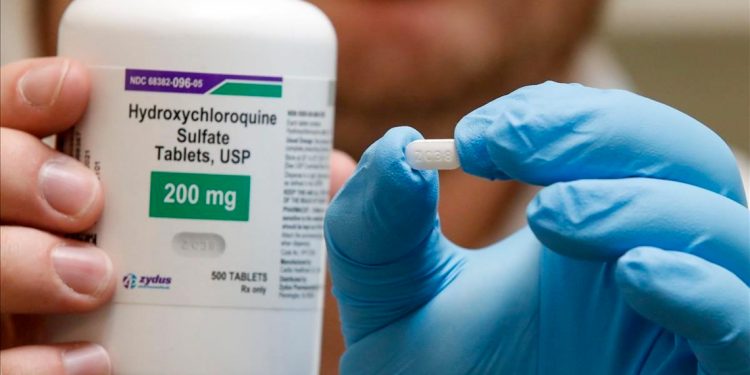 Un farmacéutico sostiene una píldora de hidroxicloroquina. Foto: AFP/George Frey.