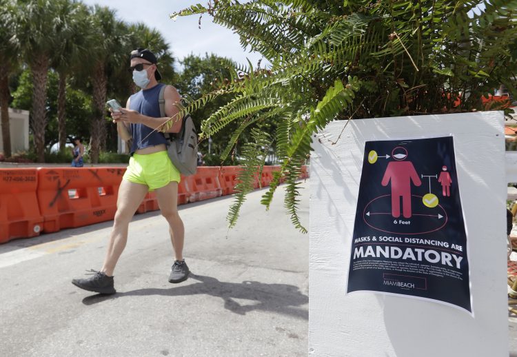 Una persona que porta una mascarilla camina por Miami Beach, en Florida, el sábado 4 de julio de 2020. (AP Foto/Wilfredo Lee)