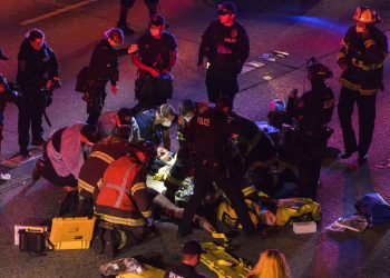 Trabajadores de emergencias atienden a una persona herida tras un atropello en una protesta en la Interestatal 5 en Seattle. Dawit Kelete, de 27 años, fue detenido y acusado de dos delitos de agresión con vehículo, según las autoridades. (James Anderson via AP)
