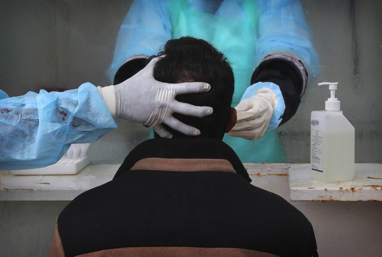 Personal médico extrae una muestra nasal a una persona para una prueba de detección del coronavirus en un hospital gubernamental en Hyderabad, India, el 23 de julio de 2020. (AP Foto/Mahesh Kumar A.)