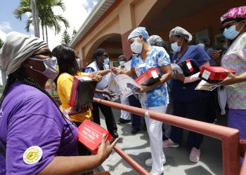 Trabajadores entregan cubrebocas para prevenir el contagio del coronavirus en una residencia y centro de rehabilitación de ancianos en Miami, 20 de julio de 2020. Foto: Wilfredo Lee/AP.
