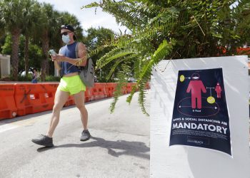Una persona que porta una mascarilla camina por Miami Beach, en Florida, el sábado 4 de julio de 2020. Foto: AP/Wilfredo Lee.