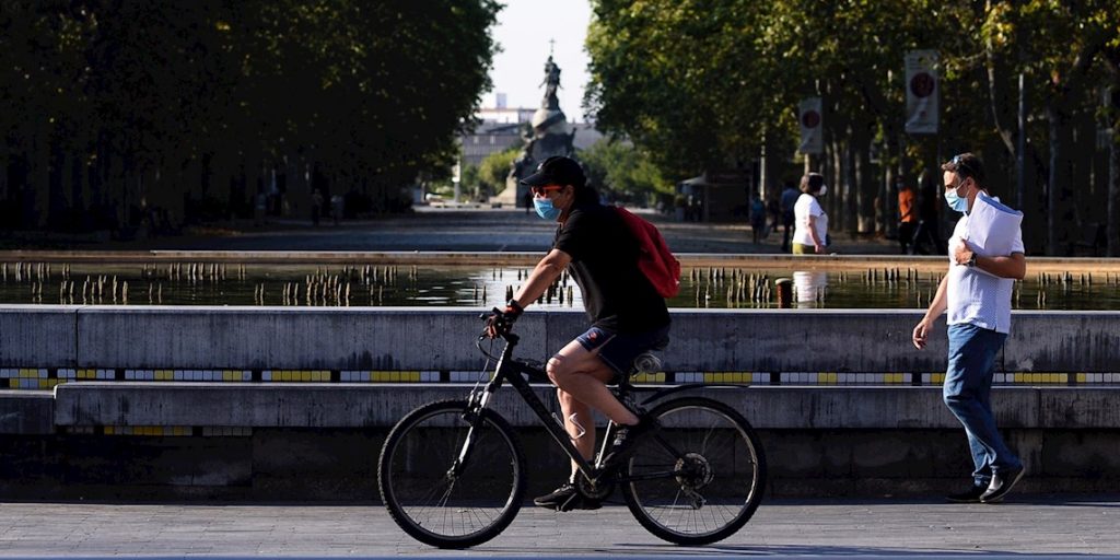 Un hombre circula en bicicleta y con mascarilla por el centro de la ciudad de Valladolid (España) donde este viernes las temperaturas superarán los 35 grados centígrados. Foto: EFE/Nacho Gallego.