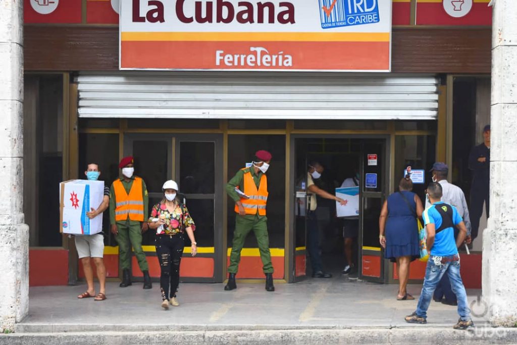 Compradores y policías en las afueras de la tienda La Cubana, de la calle Reina en La Habana, una de las nuevas tiendas que iniciaron la venta de artículos en Moneda Libremente (MLC) este lunes 20 de julio de 2020, como parte de las nuevas medidas económicas del gobierno cubano. Foto: Otmaro Rodríguez.